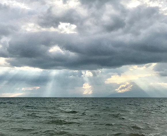 a body of water with clouds above it