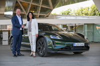 a man and woman standing next to a car